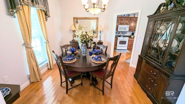 dining room with light wood-type flooring and a chandelier