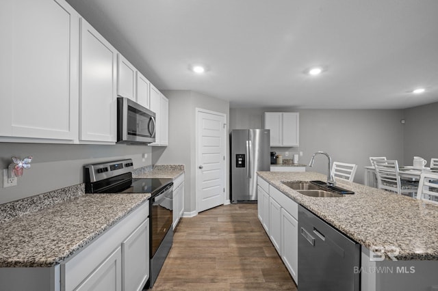 17208 Muse St, Loxley, AL 36551 - kitchen with stainless steel appliances, a sink, recessed lighting, wood finished floors, and a kitchen island with sink