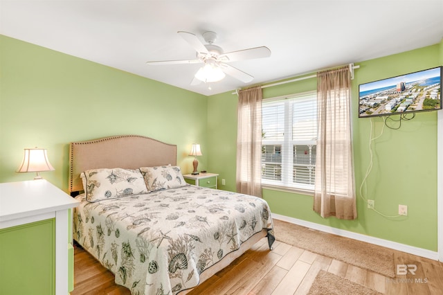 bedroom featuring light wood-style flooring, baseboards, and ceiling fan