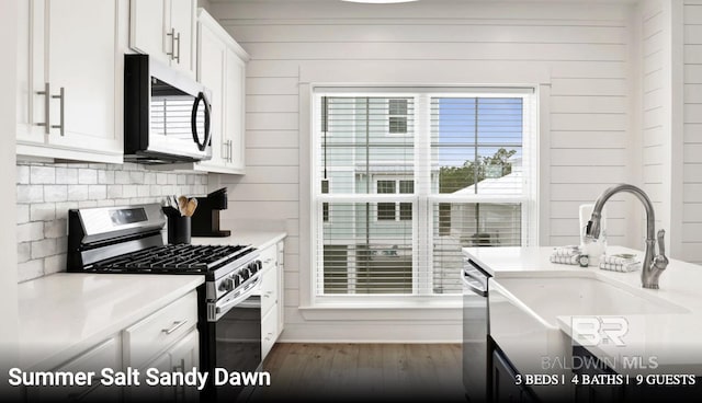 2760 Salt Dr, Orange Beach, AL 36561 - kitchen featuring white cabinets, stainless steel appliances, a sink, tasteful backsplash, and dark wood-type flooring