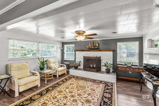 7410 Helton Dr, Foley, AL 36535 - living room featuring healthy amount of natural light, a ceiling fan, wood finished floors, a fireplace, and crown molding
