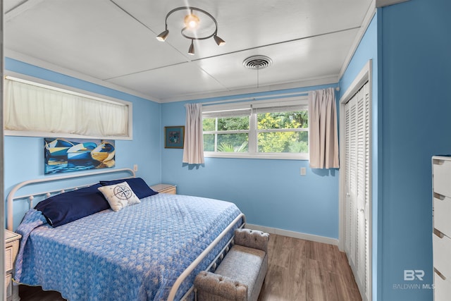 7410 Helton Dr, Foley, AL 36535 - bedroom featuring wood finished floors, a closet, ornamental molding, and baseboards