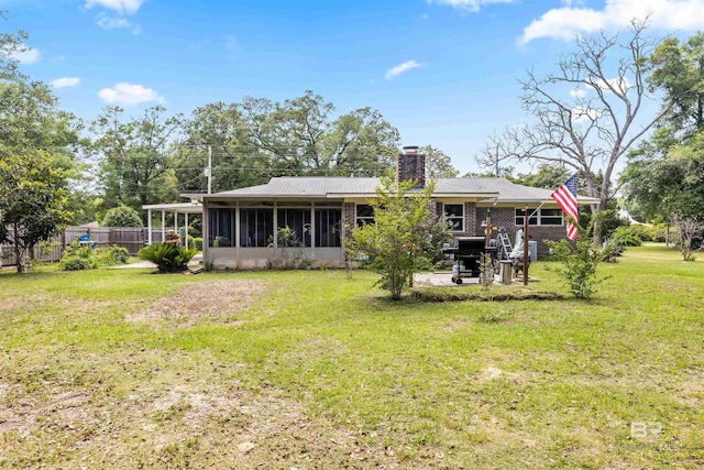 7410 Helton Dr, Foley, AL 36535 - back of property featuring a sunroom, a chimney, and a patio