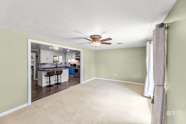 7410 Helton Dr, Foley, AL 36535 - living room featuring light carpet, ceiling fan, and baseboards