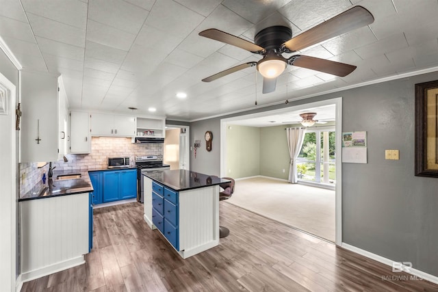 7410 Helton Dr, Foley, AL 36535 - kitchen with blue cabinets, stainless steel appliances, dark countertops, a sink, and ornamental molding