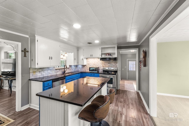 7410 Helton Dr, Foley, AL 36535 - kitchen featuring appliances with stainless steel finishes, dark countertops, ventilation hood, open shelves, and a center island