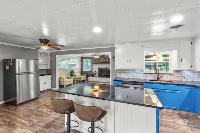 7410 Helton Dr, Foley, AL 36535 - kitchen with stainless steel appliances, a sink, a ceiling fan, blue cabinetry, and white cabinets