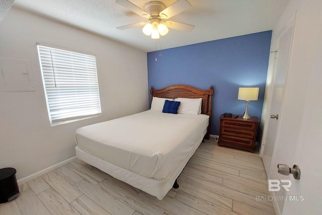 bedroom featuring a textured ceiling, ceiling fan, and light wood-type flooring