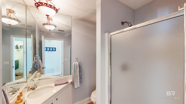 bathroom featuring visible vents, toilet, a stall shower, baseboards, and vanity