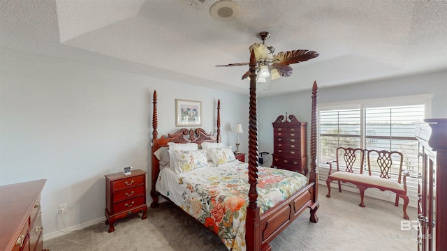 bedroom featuring baseboards, light carpet, a textured ceiling, and ceiling fan