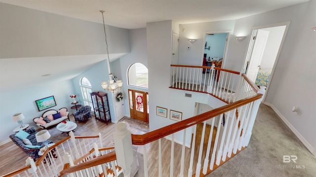 stairway featuring an inviting chandelier, a high ceiling, and baseboards