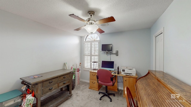 office featuring light carpet, a textured ceiling, and ceiling fan