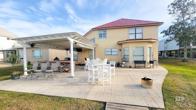 back of house featuring stucco siding, metal roof, a yard, outdoor dining space, and a patio