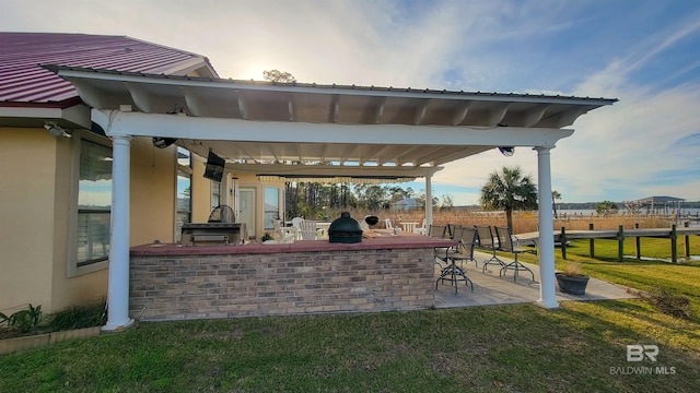 view of patio featuring outdoor dry bar, area for grilling, and fence