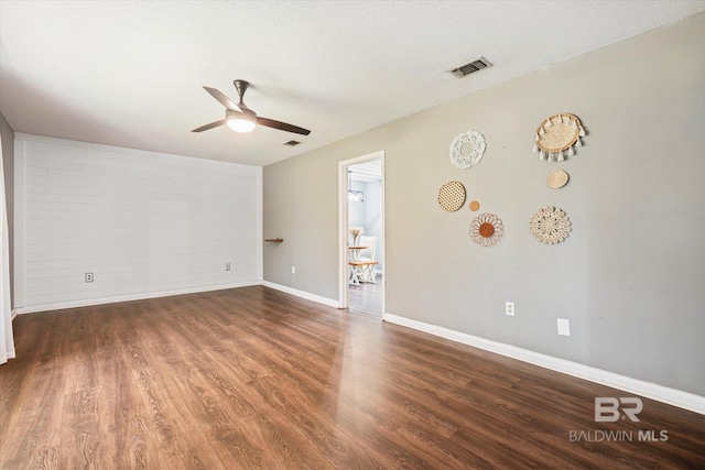 unfurnished room featuring ceiling fan, dark wood-type flooring, and a textured ceiling