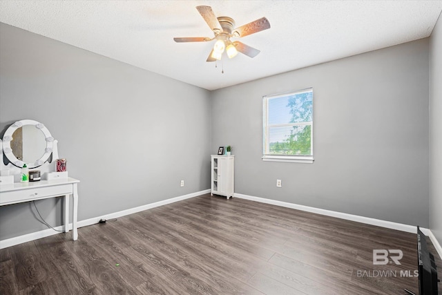 empty room featuring dark wood-type flooring, ceiling fan, and a textured ceiling