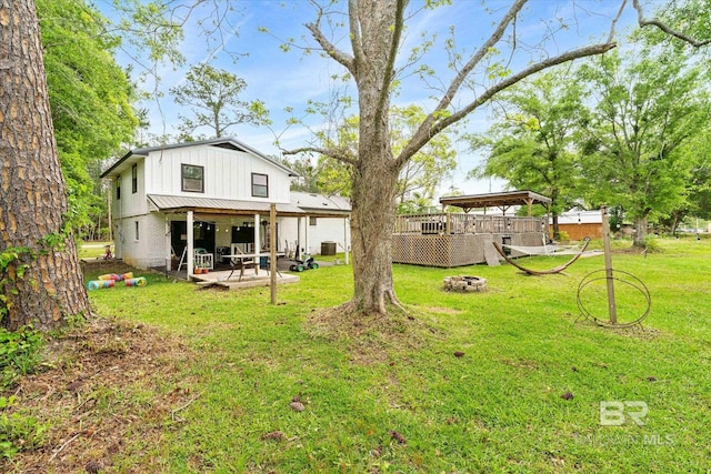 view of yard with a fire pit, a patio, and a deck