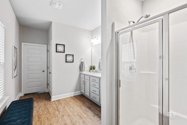 bathroom with an enclosed shower, vanity, and hardwood / wood-style flooring