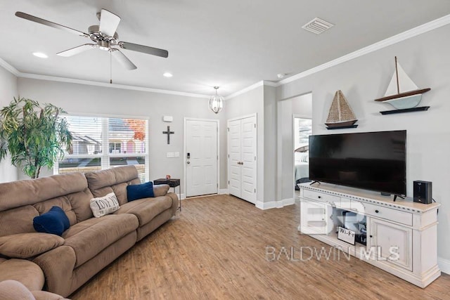 living room featuring crown molding, light hardwood / wood-style floors, and plenty of natural light