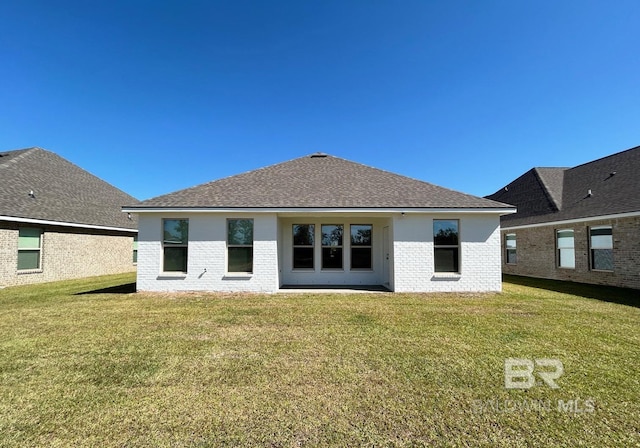 rear view of house featuring a lawn