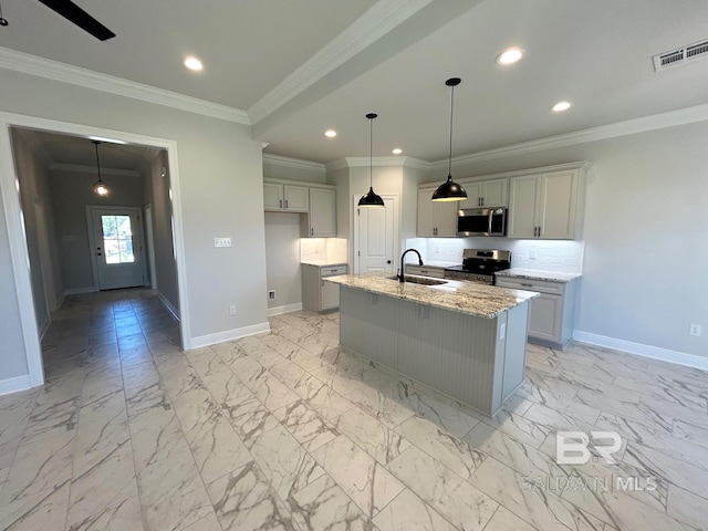 kitchen featuring a center island with sink, sink, crown molding, appliances with stainless steel finishes, and light stone counters