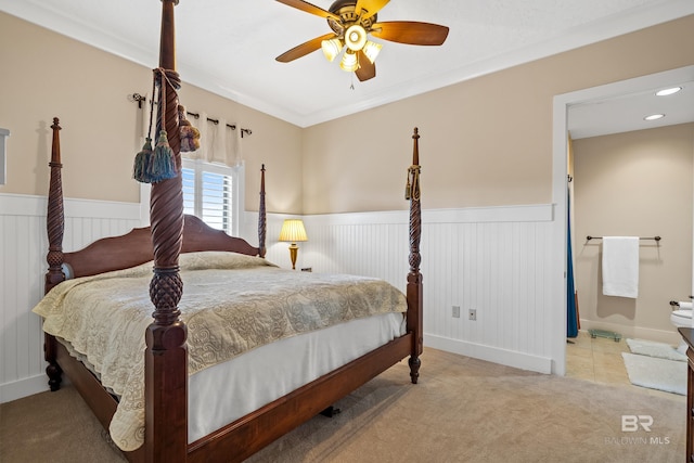 carpeted bedroom with ceiling fan and ornamental molding