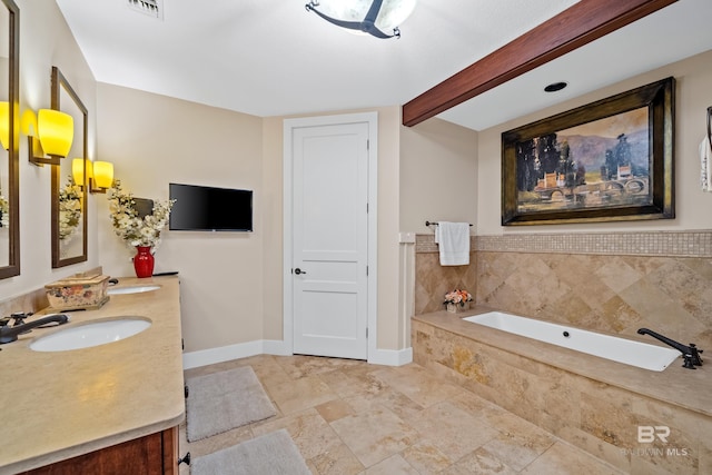 bathroom featuring beam ceiling, vanity, and tiled bath