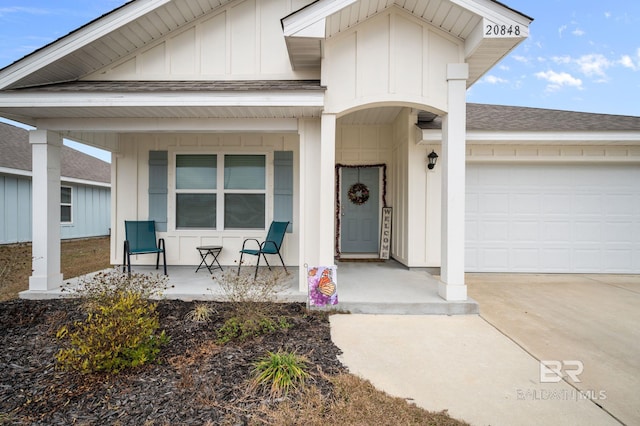 view of exterior entry with a garage and covered porch