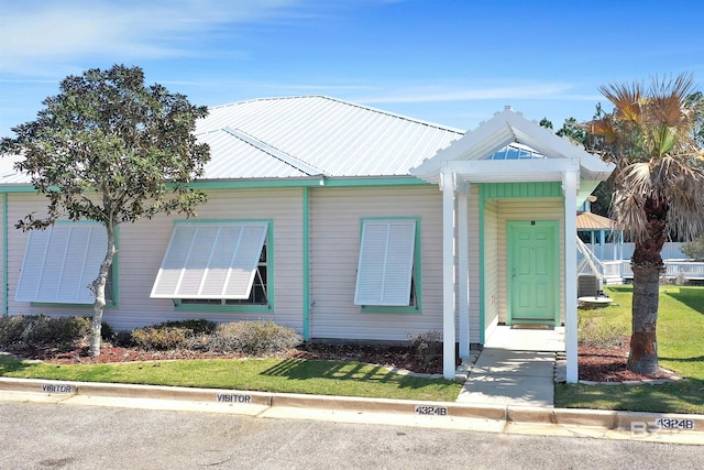 view of front facade with a front lawn and metal roof