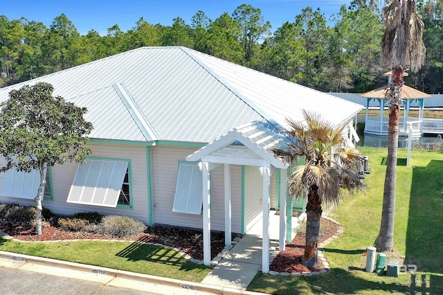 view of front facade featuring metal roof and a front lawn