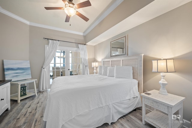 bedroom with ceiling fan, baseboards, crown molding, and wood finished floors