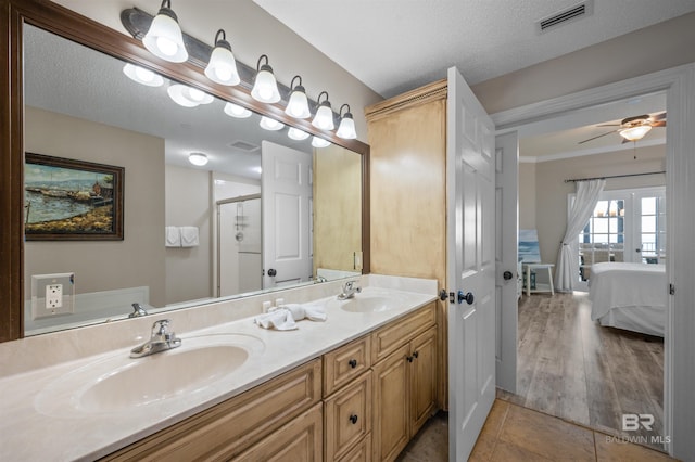 ensuite bathroom with tile patterned flooring, visible vents, a sink, and french doors