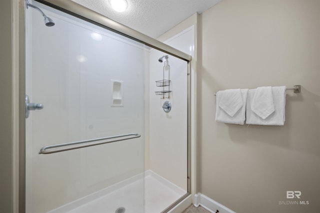 full bath with a stall shower and a textured ceiling