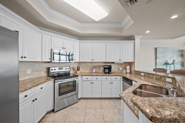 kitchen with visible vents, a raised ceiling, stainless steel appliances, crown molding, and a sink