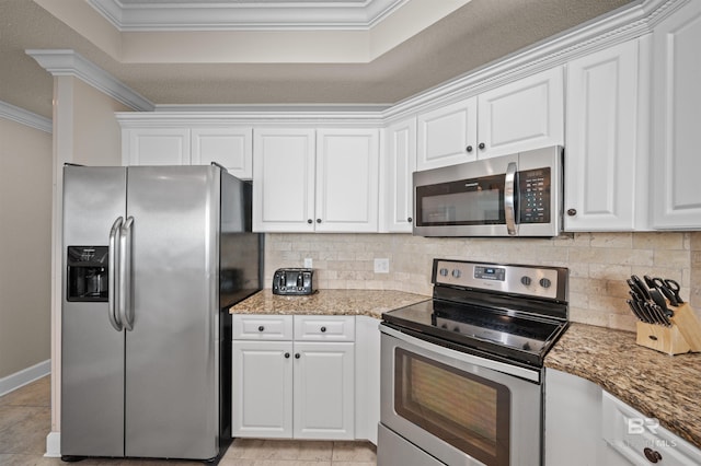 kitchen featuring appliances with stainless steel finishes, white cabinets, ornamental molding, and decorative backsplash