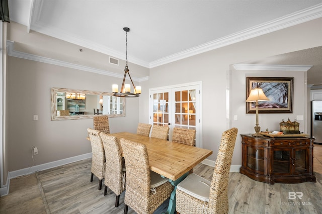 dining room with baseboards, visible vents, crown molding, french doors, and light wood-style floors