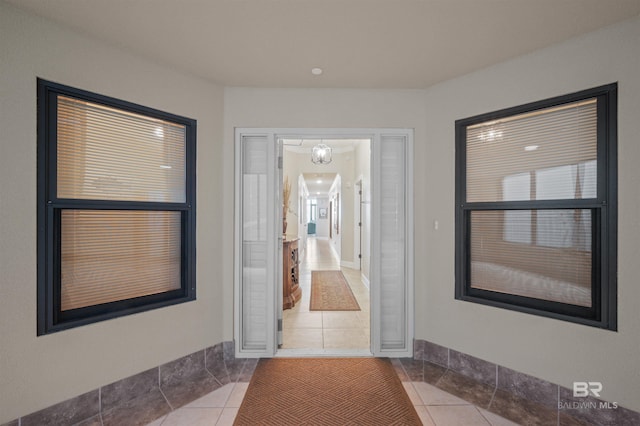 hallway with tile patterned flooring and baseboards