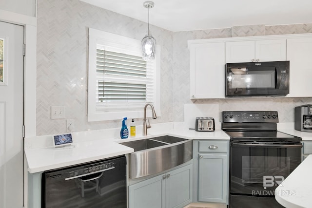 kitchen with black appliances, backsplash, light countertops, and a sink
