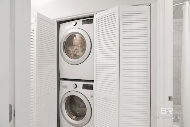 washroom with stacked washer / drying machine and laundry area