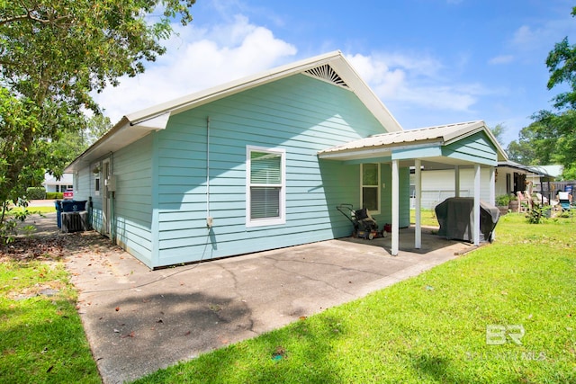 rear view of property featuring a patio and a yard