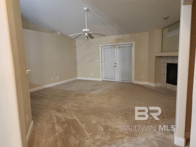 unfurnished living room featuring baseboards, light colored carpet, lofted ceiling, ceiling fan, and a fireplace