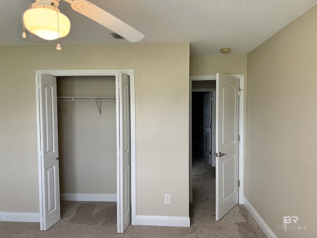 unfurnished bedroom featuring a textured ceiling, a closet, carpet, and baseboards