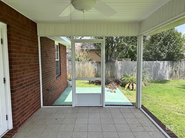 unfurnished sunroom featuring a ceiling fan