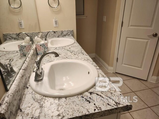 bathroom with double vanity, a sink, and tile patterned floors