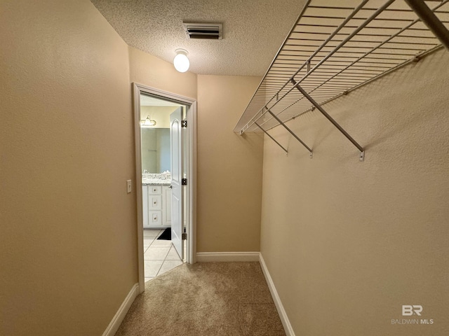 spacious closet featuring visible vents and light colored carpet