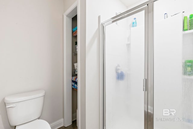 bathroom featuring an enclosed shower and toilet