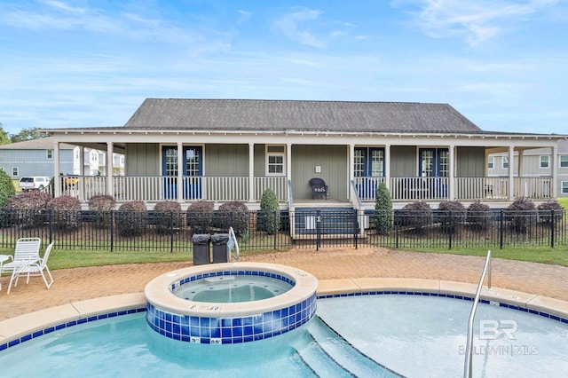 view of pool with a hot tub