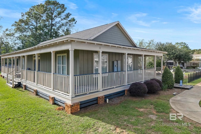 view of side of property featuring a lawn and a porch