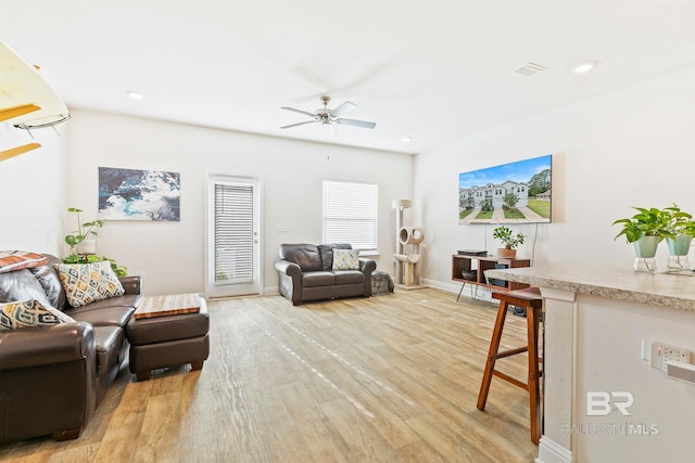 living room with light hardwood / wood-style floors and ceiling fan