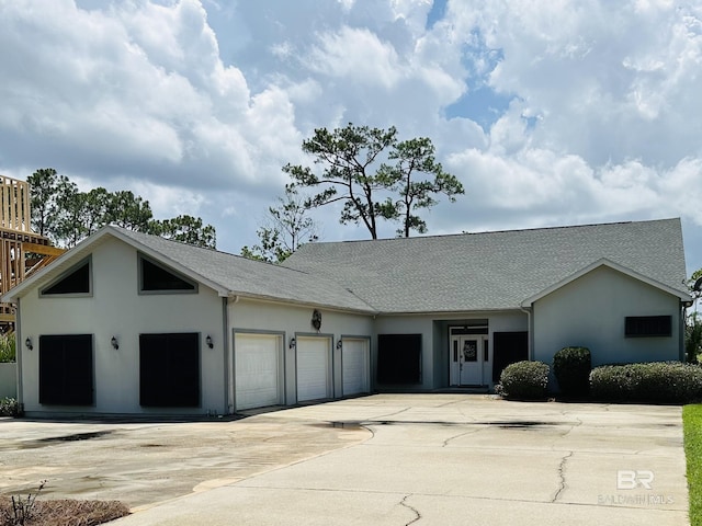 8585 Bay Harbor Rd, Elberta, AL 36530 - view of front of house with stucco siding, an attached garage, driveway, and roof with shingles
